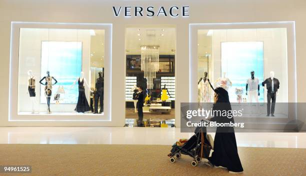 Woman shopper walks past a Versace store in the Dubai Mall which is owned by Emaar Properties PJSC in Dubai, United Arab Emirates, on Sunday, July...