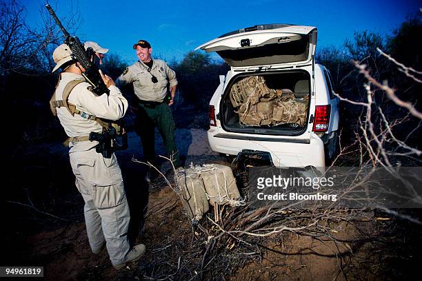 Paul McKenna, a U.S. Border Patrol Search, Trauma, and Rescue agent, left, speaks with a Pima County Sheriff's officer after chasing down drug...