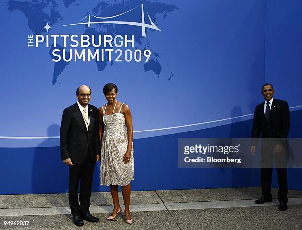 President Barack Obama, right, stands by as U.S. First lady Michelle Obama, center, is photographed with Tharman Shanmugaratnam, Singapore's minister...