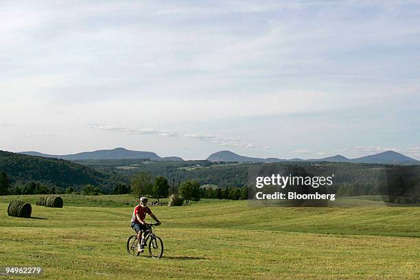 Cyclist rides through a pasture on the Kingdom Trails in East Burke, Vermont, U.S., on Wednesday, June 17, 2009. Kingdom Trails features 100 miles of...