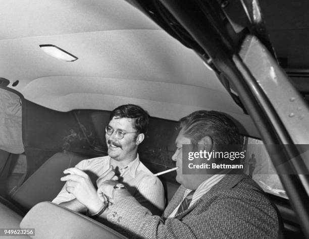 Edmund KemperIII enjoys a smoke as unidentified detective adjusts his handcuffs after Kemper appeared in Pueblo District court extradition hearing....