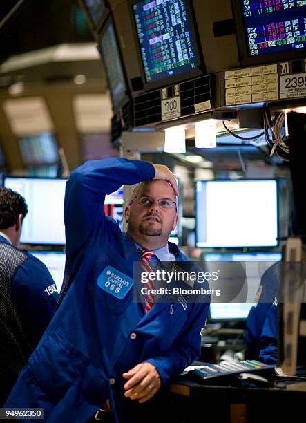 Trader holds his head while working on the floor of the New York Stock Exchange in New York, U.S., on Thursday, July 2, 2009. U.S. Stocks fell,...