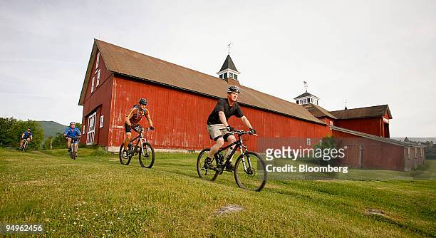 Cyclists ride past a barn on the Kingdom Trails in East Burke, Vermont, U.S., on Wednesday, June 17, 2009. Kingdom Trails features 100 miles of...