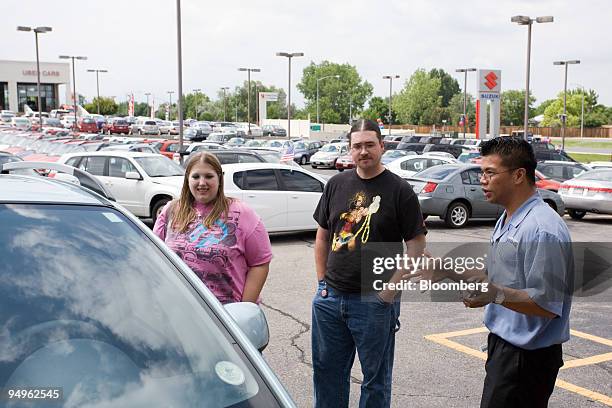 Sarah Jean Peters, left, and Neil Greenaway talk with salesman Bernard Quisumbing, right, prior to purchasing a Suzuki SX4 at Denver Isuzu Suzuki in...