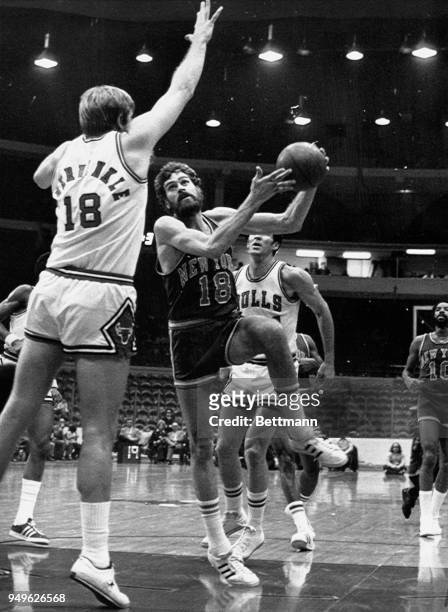 Phil Jackson of New York goes up for a shot in the first half at Chicago stadium against the Bulls. Trying to block shot is Bulls' Tom Boerwinkle and...