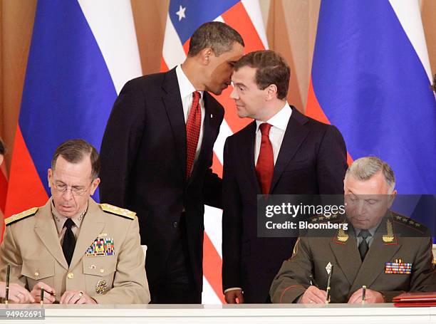 Barack Obama, U.S. President, standing left, talks to Dmitry Medvedev, Russia's president, standing right, as Admiral Michael Mullen, head of the...