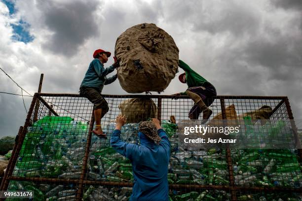 Workers collect plastic bottles in a village that thrives on waste segregation for a living on April 18, 2018 in Manila, Philippines. The Philippines...