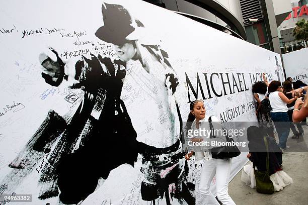 Fans sign a mural of Michael Jackson outside the Staples Center where the public memorial for Jackson is being held in Los Angeles, California, U.S....