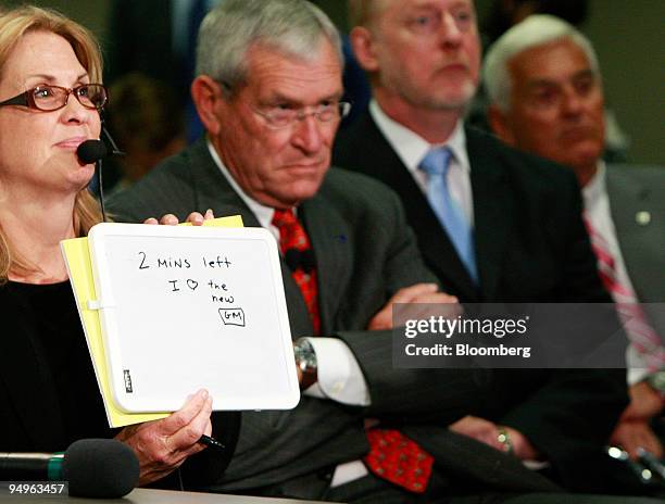 Jody Sherwin, left, holds up a message reading "2 mins left" and "I love the new GM" for Fritz Henderson, chief executive officer of General Motors...