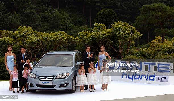 Models pose with Hyundai Motor Co's Elantra LPI Hybrid vehicle during the launch in Gapyeong, South Korea, on Wednesday, July 8, 2009. Hyundai Motor...
