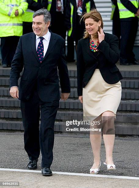 Gordon Brown, U.K. Prime minister, left, walks with his wife Sarah, as he heads to board his flight for the G8 Summit in L'Aquila from London...