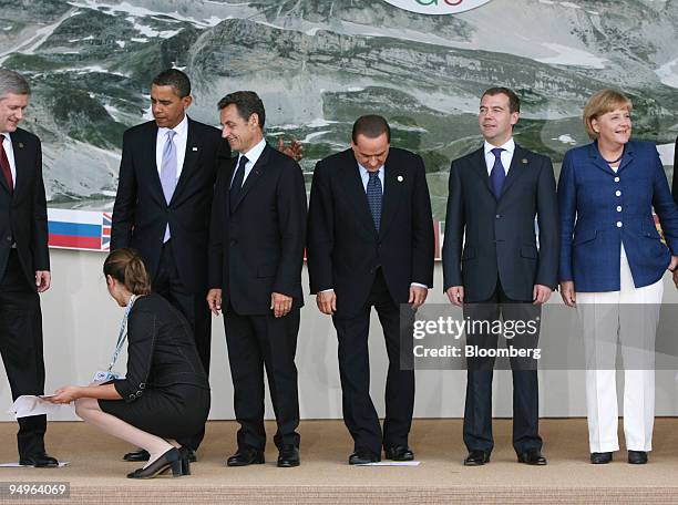 Member of the G8 staff removes name templates watched by U.S. President Barack Obama, left to right, Nicolas Sarkozy, France?s president, Silvio...