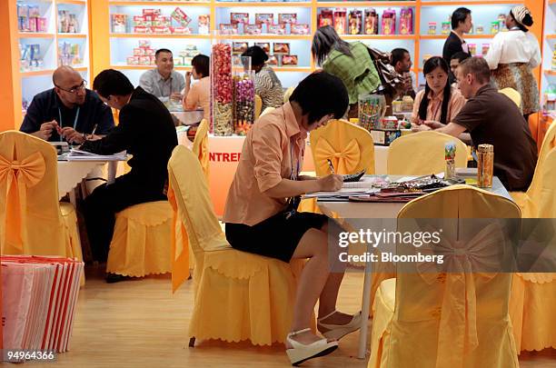 Buyers and sellers conduct business at the booth of a food manufacturer, at the 106th China Import and Export Fair in Guangzhou, China, on Tuesday,...