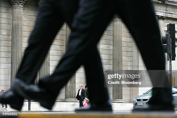 Businessmen walk past the Bank of England in London, U.K., on Thursday, July 9, 2009. The Bank of England stuck to its plan to buy bonds with 125...