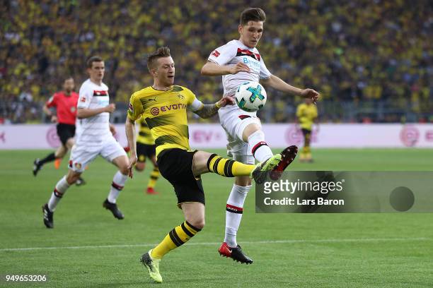 Marco Reus of Dortmund fights for the ball with Panagiotis Retsos of Leverkusen during the Bundesliga match between Borussia Dortmund and Bayer 04...