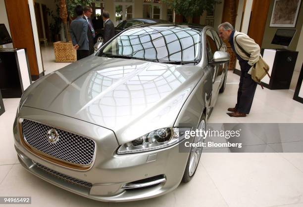 Visitor looks at the new Jaguar XJ saloon car on display at the Salon Prive luxury super car show in London, U.K., on Wednesday, July 22, 2009. The...