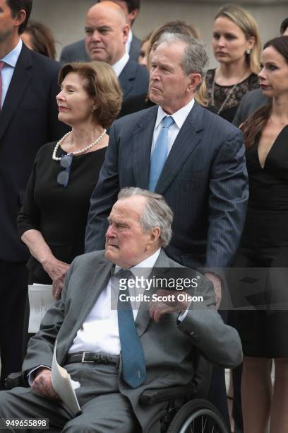 Former president George H.W. Bush, former president George W. Bush, former first lady Laura Bush and family watch as the coffin of former first lady...