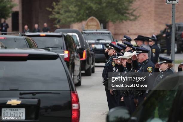 Police salute as the remains of former first lady Barbara Bush leave St. Martin's Episcopal Church following her funeral service on April 21, 2018 in...