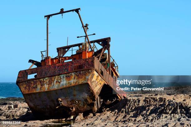 rusty wreck of a fish trawler on the rocky shore, cabo raso, near camarones, chubut, argentina - raso 個照片及圖片檔