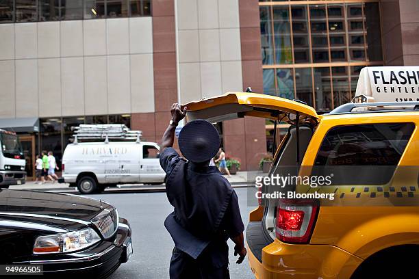 Bellhop who identified himself only as Jack closes the tailgate of a taxi after loading luggage outside a Sheraton Hotel in New York, U.S., on...
