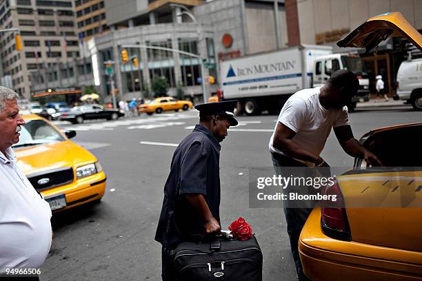 Bellhop who identified himself only as Jack carries a guest's luggage to a taxi outside a Sheraton Hotel in New York, U.S., on Wednesday, Aug. 5,...
