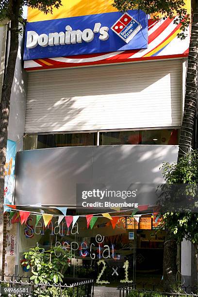 Signage is displayed outside a Domino's restaurant in Mexico City, Mexico, on Thursday, Aug. 6, 2009. Domino's Pizza, the second-largest U.S. Pizza...