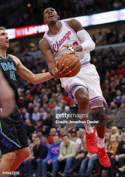 Kris Dunn of the Chicago Bulls drives past Dirk Nowitzki of the Dallas Mavericks at the United Center on March 2, 2018 in Chicago, Illinois. The...