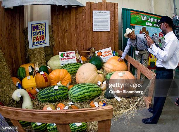 Jon Hagler, director of agriculture for the state of Missouri, left, shows some prize winning watermelons and pumpkins to Mohammad Hussein Safi,...