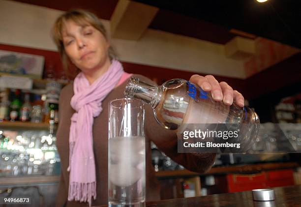 Bartender pours a glass of Absolut Vodka, produced by Pernod Ricard, in a bar in Paris, France, on Thursday, Sept. 3, 2009. Pernod Ricard SA, the...