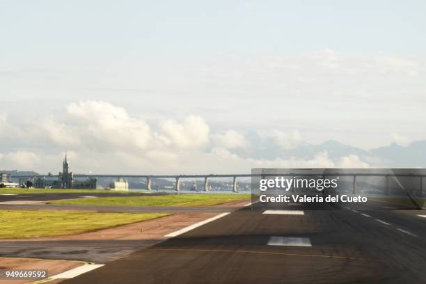 from the santos dumont airport runway the fiscal islando in guanabara bay, rio de janeiro. in the background the ponte rio - niterói - valeria del cueto stock pictures, royalty-free photos & images