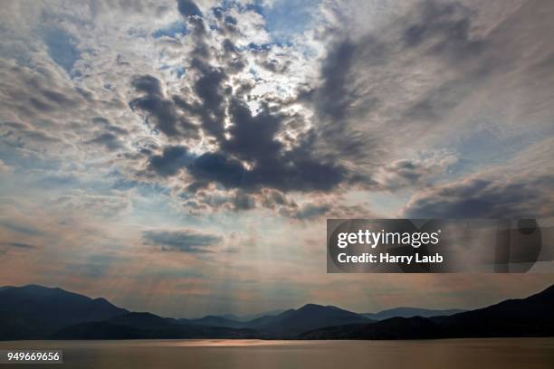 dramatic cloud formation, sunbeams behind dark clouds, thunderstorm atmosphere, lago maggiore, verbano-cusio-ossola province, piedmont region, italy - province of verbano cusio ossola stock pictures, royalty-free photos & images