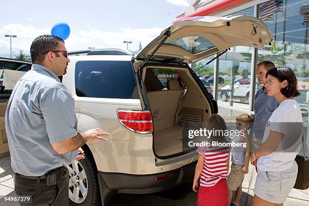 Lynn, right, and Patrick Wentland, second right, with their daughters Cassidy third right, and Alexandra look at a Saturn Outlook at the Saturn of...