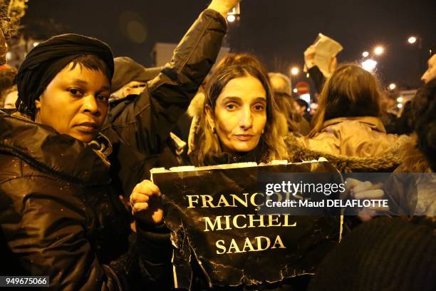 Femme brandissant le nom d'une des victimes assassinée sur une affiche lors du rassemblement en hommage aux victimes de l'attentat de l'épicerie...