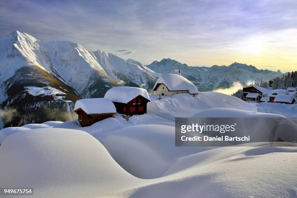 deep snow-covered mountain village, bettmeralp with chapel maria zum schnee in the evening light, canton valais, switzerland - mountain village stockfoto's en -beelden