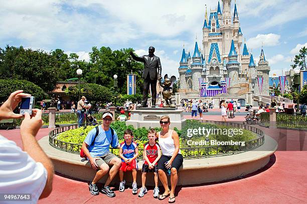 Visitors have their photo taken in front of Cinderalla Castle at Magic Kingdom, part of the Walt Disney World theme park and resort in Lake Buena...