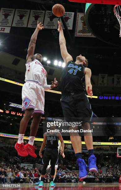 Dirk Nowitzki of the Dallas Mavericks leaps to try and block a shot by Kris Dunn of the Chicago Bulls at the United Center on March 2, 2018 in...