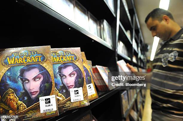 Ali Guettouche looks at a "World of Warcraft" video game on display at a store in Paris, France, on Tuesday, Sept. 1, 2009. Vivendi SA, owner of the...