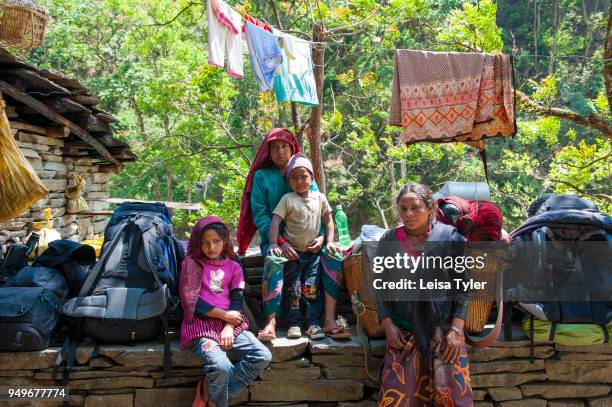 Local villagers with trekkers packs at the hot springs at Tatopani on the Manaslu Circuit, a 3 days walk from the trailhead at Arughat Bazaar. The...