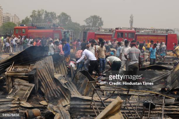 Firemen, Policemen and people trying to douse fire in sector-49 slums on April 21, 2018 in Gurgaon, India. Around 150 shanties turned into ashes near...