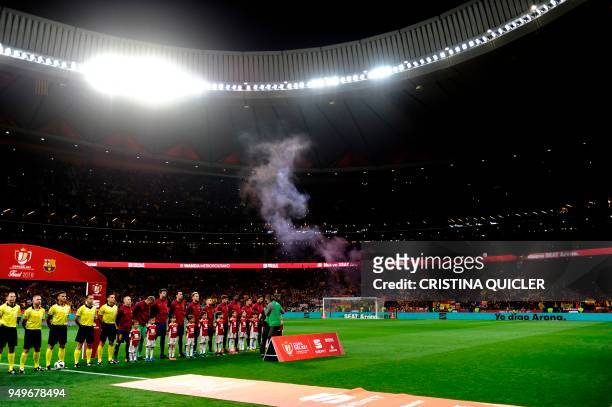 Barcelona's players listen to the Spanish anthem before the Spanish Copa del Rey final football match Sevilla FC against FC Barcelona at the Wanda...