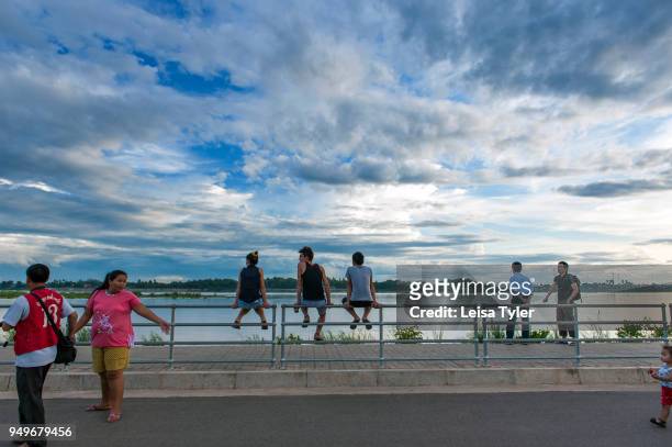 People relaxing by the banks of the Mekong River in Vientiane, the capital of the Lao PDR; Thailand is the land on the opposite side.