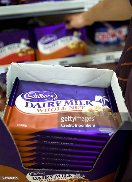 An employee replenishes shelves with bars of Cadbury's Dairy Milk in a store in Hornchurch, U.K., on Monday, Sept. 7, 2009. Kraft Foods Inc., the...