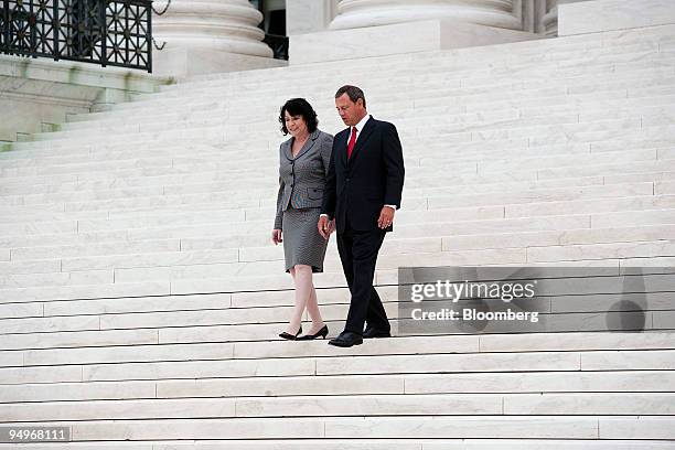 Supreme Court Justice Sonia Sotomayor, left, walks down the steps of the court with Chief Justice John Roberts, after taking a ceremonial oath of...