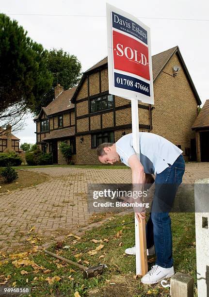 John Whelan, of Cannell Signs, places an estate agent's 'sold' sign outside a residential property in Hornchurch, Essex, U.K., on Wednesday, Sept. 9,...