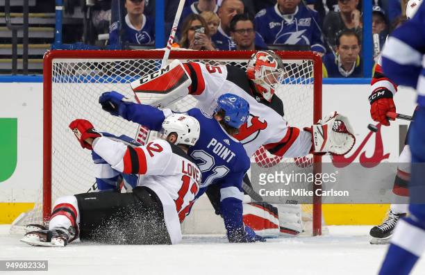 Brayden Point of the Tampa Bay Lightning is taken down by Ben Lovejoy of the New Jersey Devils into Cory Schneider in the first period of Game Five...