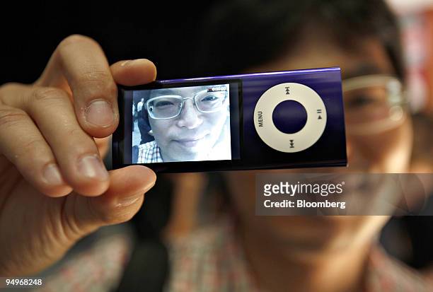 Nobuyuki Okada holds an iPod Nano following its debut in San Francisco, California, U.S., on Wednesday, Sept. 9, 2009. The new Nano has a built in...