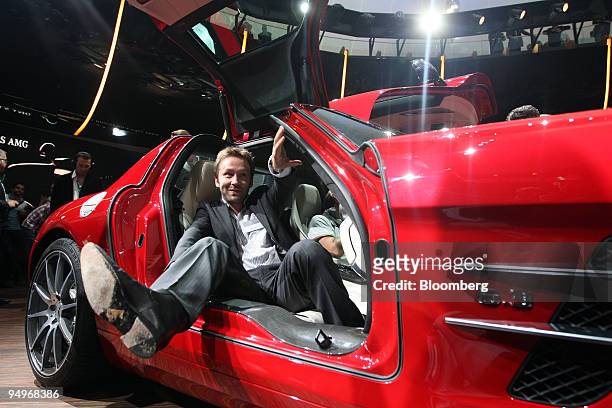 Visitor exits a Mercedes SLS AMG automobile at its premiere on the first press day of the Frankfurt Motor Show, in Frankfurt, Germany, on Tuesday,...