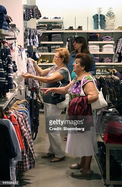 Shoppers look at clothes on display in a Zara store in Madrid, Spain, on Tuesday, Sept. 15, 2009. Inditex report earnings tomorrow.