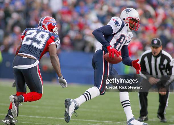 Randy Moss of the New England Patriots runs to the sidelines as Drayton Florence of the Buffalo Bills follows at Ralph Wilson Stadium on December 20,...