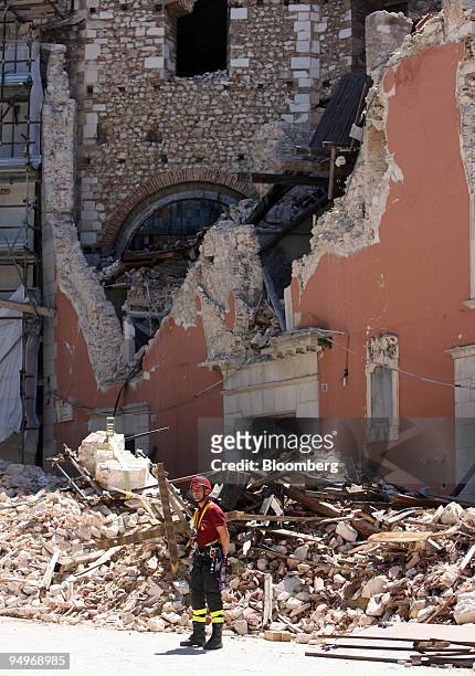 Rescue worker stands next to buildings damaged by the earthquake in L'Aquila, Italy, on Thursday, July 9, 2009. Group of Eight leaders said the...